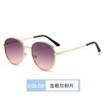 Circular sunglasses inspired by designers - gold framed gray pink lenses, gold designed eyeglass legs. Luxurious details create a high-end appearance.